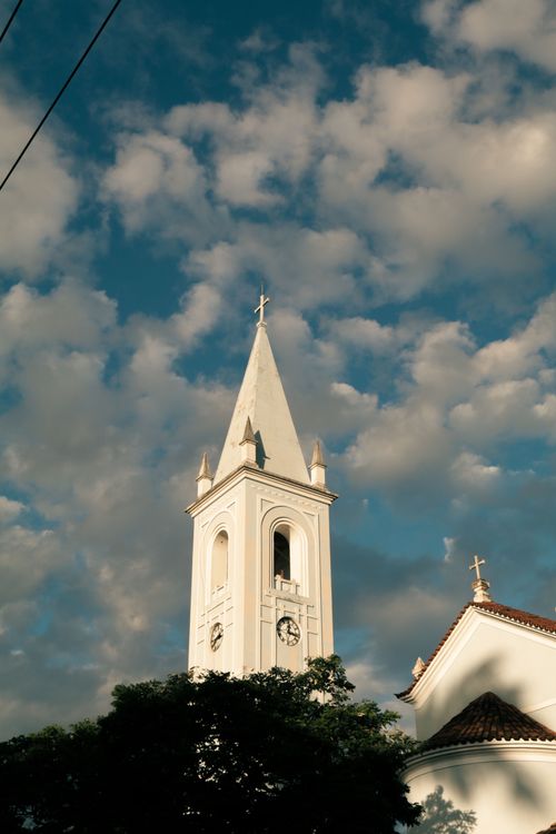 Free A beautiful church tower reaches into a cloudy blue sky, showcasing stunning architecture. Stock Photo