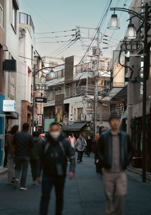 Free Street scene capturing daily life in a Japanese city with traditional architecture and overhead wiring. Stock Photo