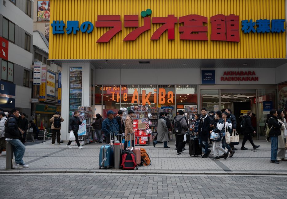 電子機器とポップカルチャーの中心地、東京・秋葉原ラジオ会館に荷物を持った群衆が集まっている。