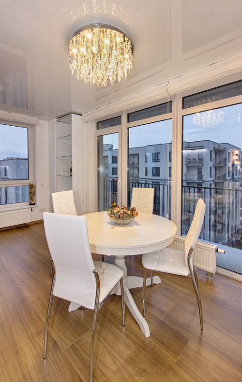 Free Stylish dining room with chic chandelier and a view of modern apartments. Stock Photo