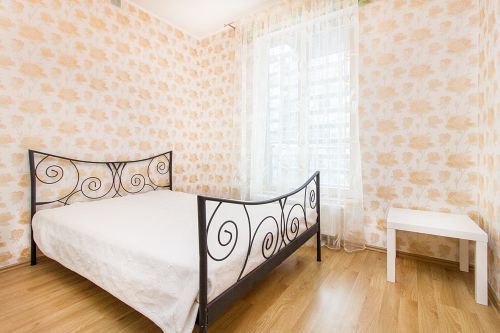 Free Bright bedroom with floral wallpaper, wrought iron bed frame, and natural light. Stock Photo