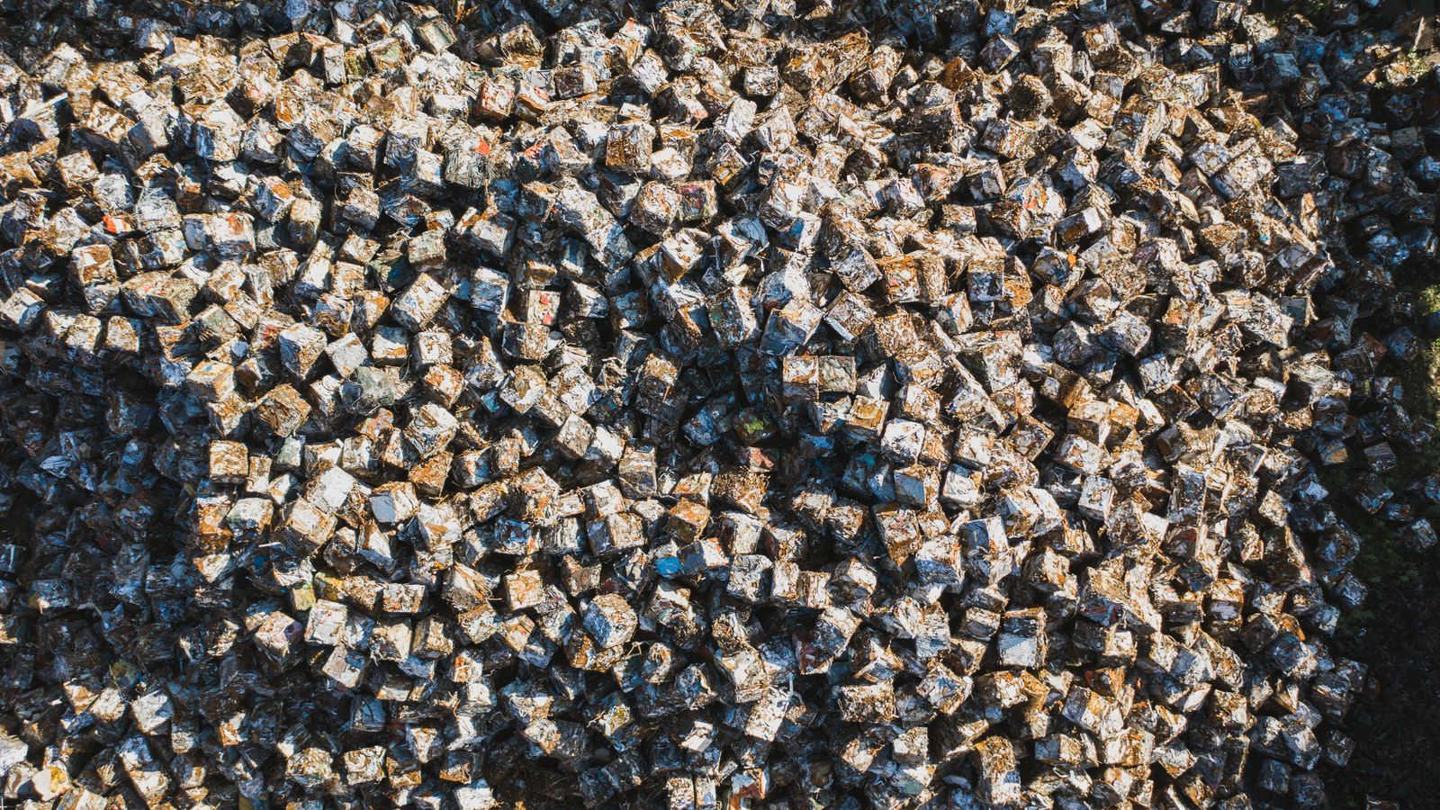 Aerial perspective of densely packed metal scrap cubes in an industrial setting, highlighting recycling.