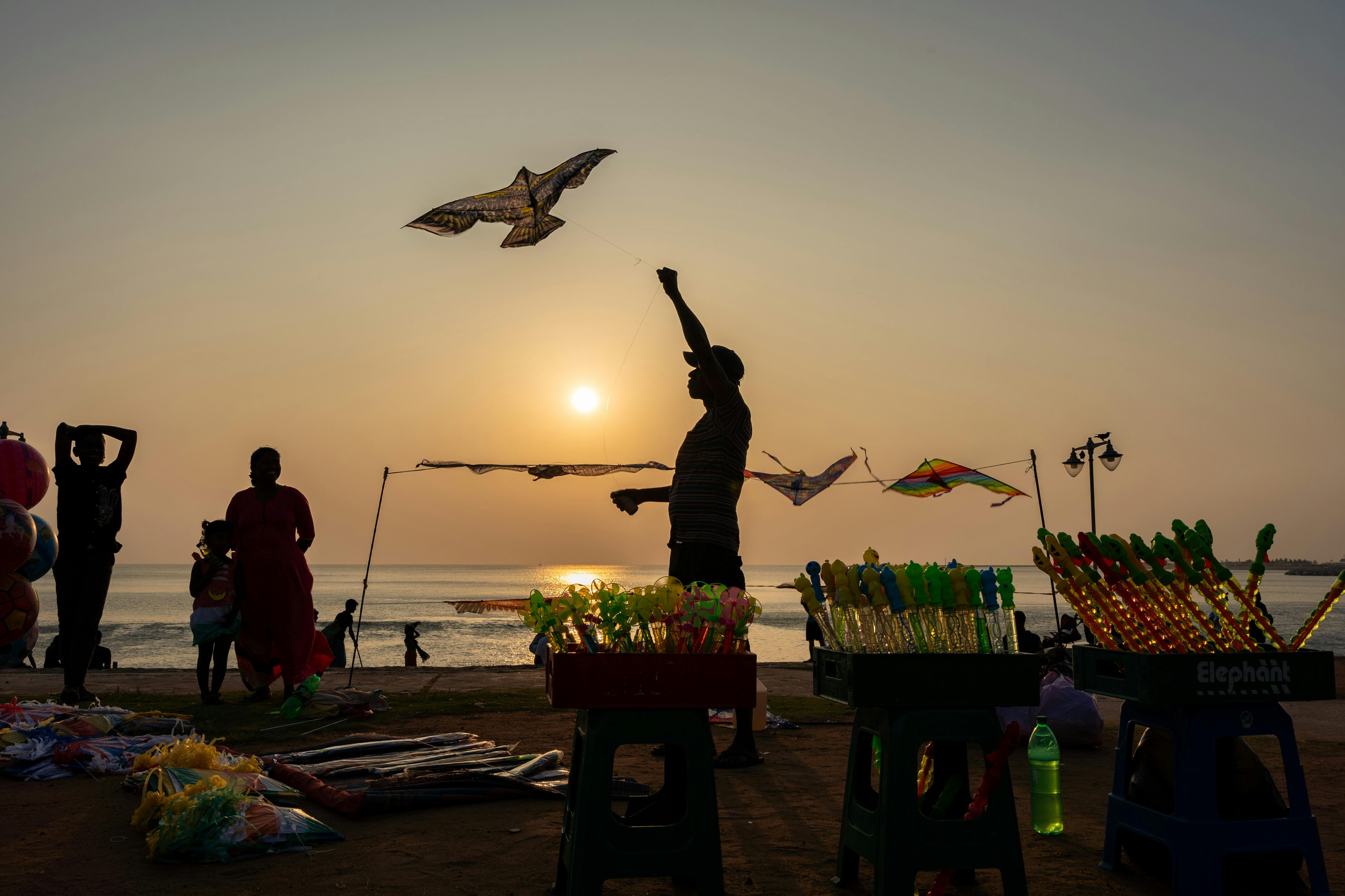 silhouette of kite flyers at colombo seaside