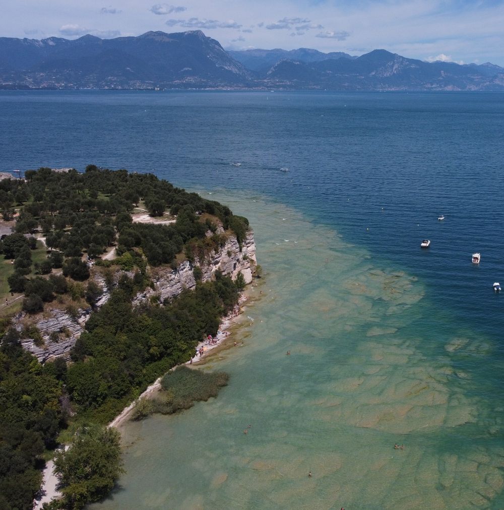 Vedere aeriană a malului Lacului Garda, cu apa albastră întinsă