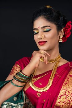 Stunning portrait of an Indian woman in a vibrant sari showcasing traditional jewelry.