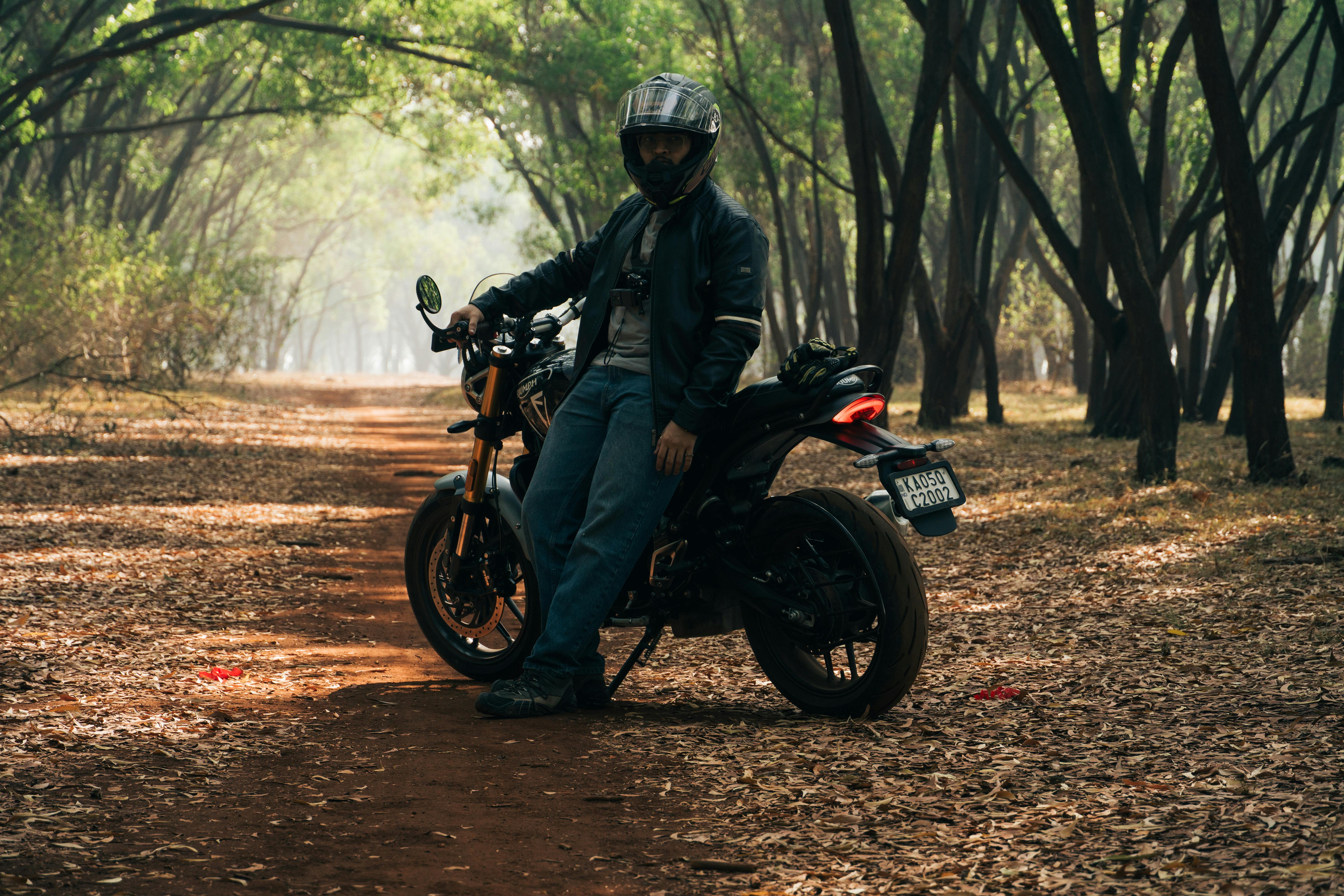 A motorcyclist enjoys an adventure trail ride through a scenic Bengaluru forest.