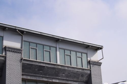 Free A contemporary brick building featuring large glass windows under a clear sky. Stock Photo
