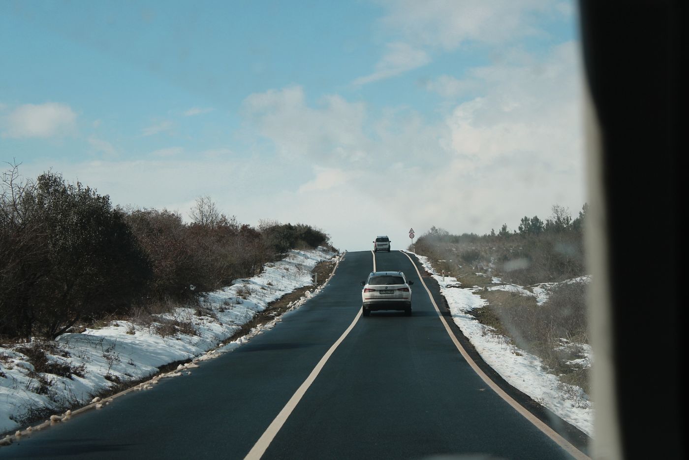 Fahrzeuge auf einer schneebedeckten Straße im Winter.