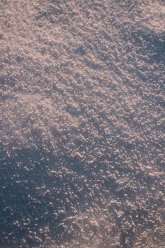 A detailed close-up shot capturing the texture of fresh snow on the ground.
