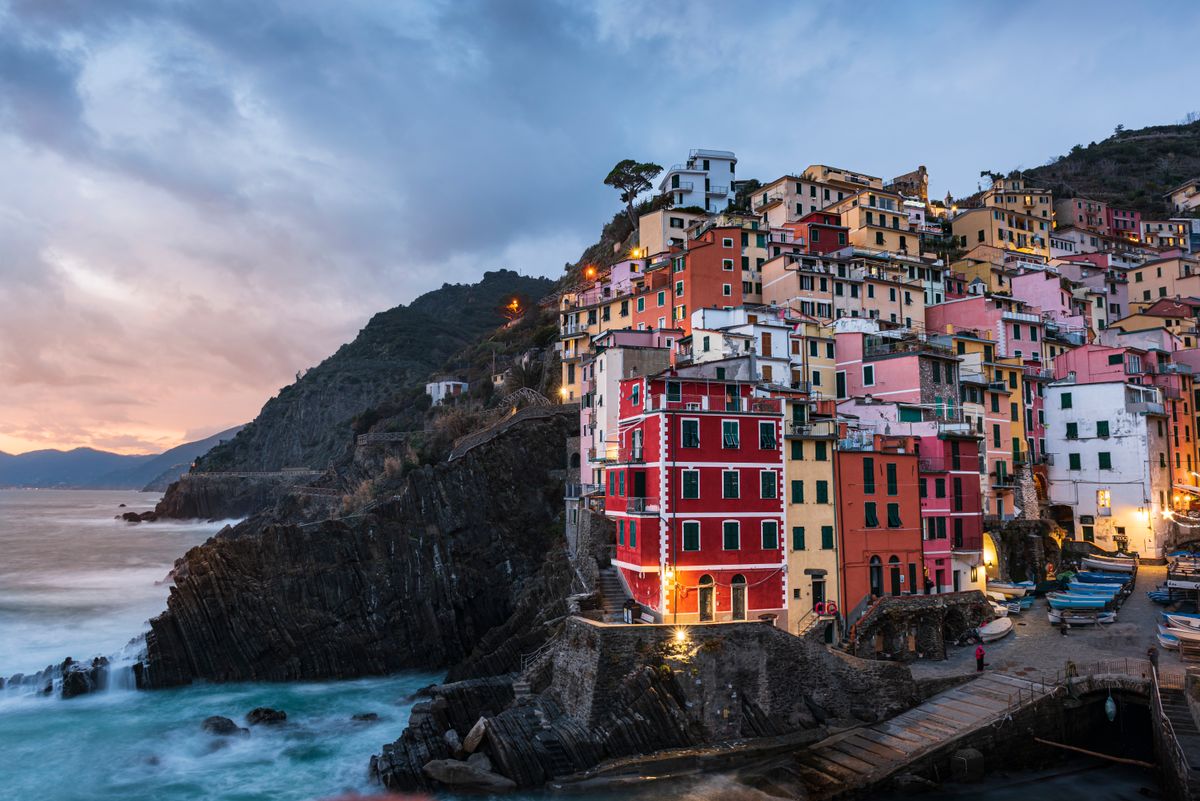 Colorful cliffside houses above the sea in Riomaggiore at sunset. Photo by Duc Tinh Ngo on Pexels
