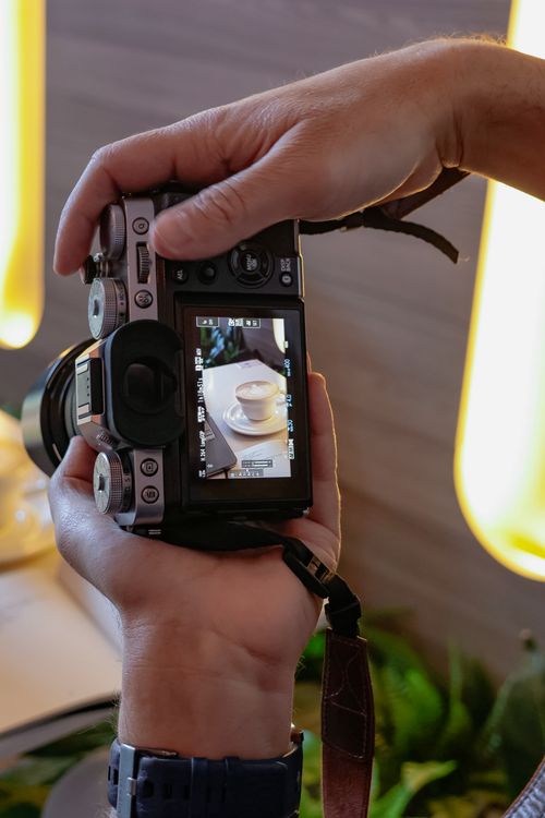 Pusle Using His Camera Young Woman Sitting Using a Laptop and a Camera · Free Stock Photo