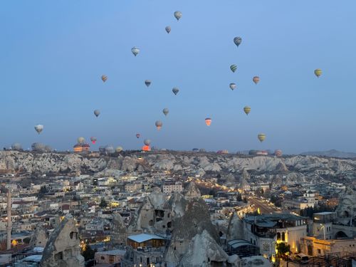 Free Hot air balloons gracefully soar over Cappadocia's unique landscape at dawn, offering an enchanting view. Stock Photo