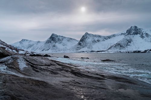 Free Serene snowy mountains and fjord in Norway under a winter sky. Stock Photo