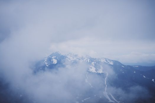 Scenic view of snow-covered mountains shrouded in mist in Lenggries, Bavaria.