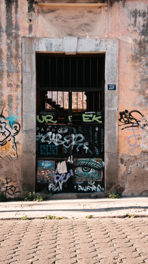 Free Vintage doorway in Puebla adorned with vibrant graffiti art, showcasing urban street culture. Stock Photo