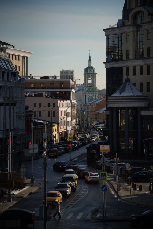 Free Busy city street with historic buildings and a prominent clock tower in the distance. Stock Photo