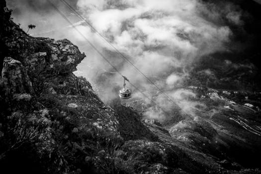Explore the dramatic views of Cape Town via its iconic cableway amidst swirling clouds.