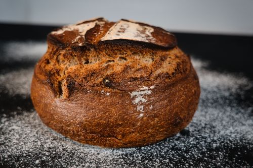 Free Close-up of a freshly baked rustic artisan bread loaf with a crunchy crust in a Berlin bakery setting. Stock Photo
