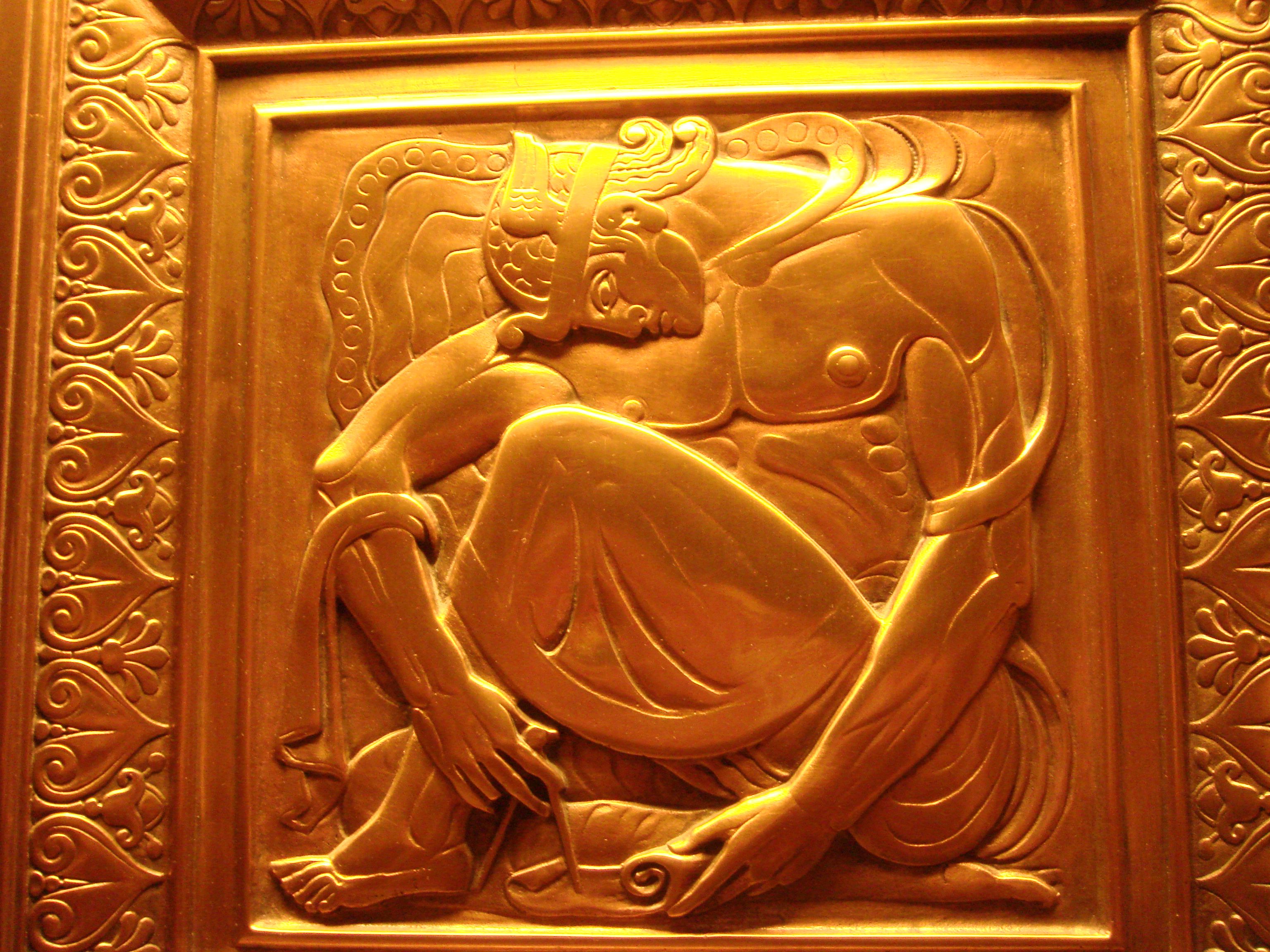Art Deco gold relief sculpture depicting mythological figure in intricate detail.