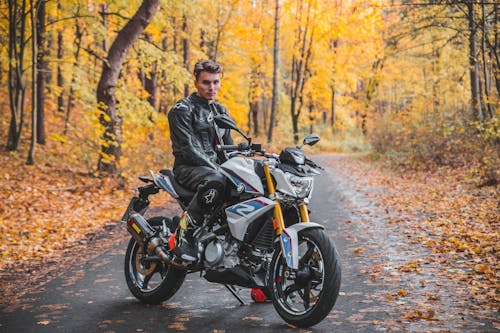 Man in Black Leather Jacket Riding On Motorcycle