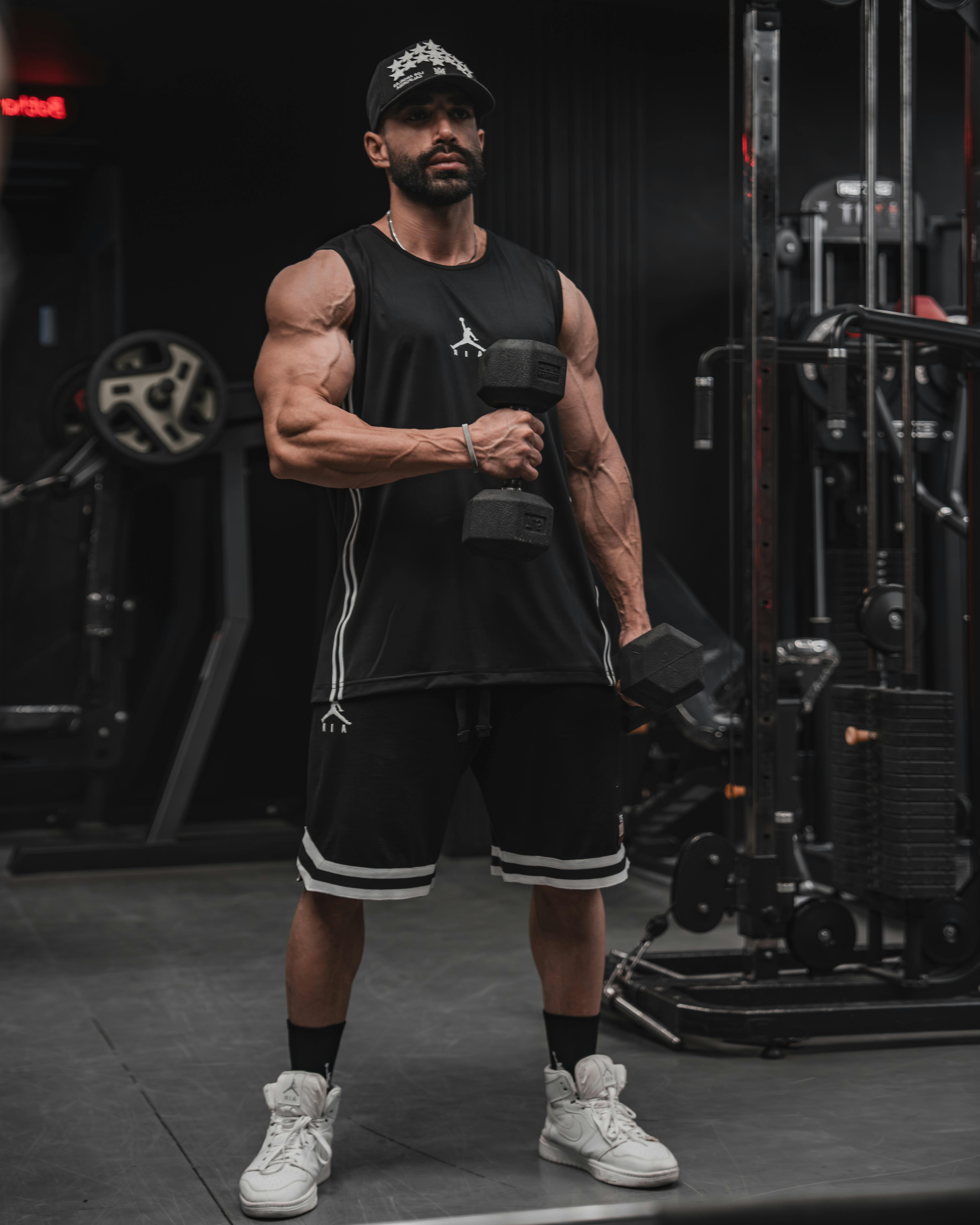 muscular man lifting dumbbells in gym