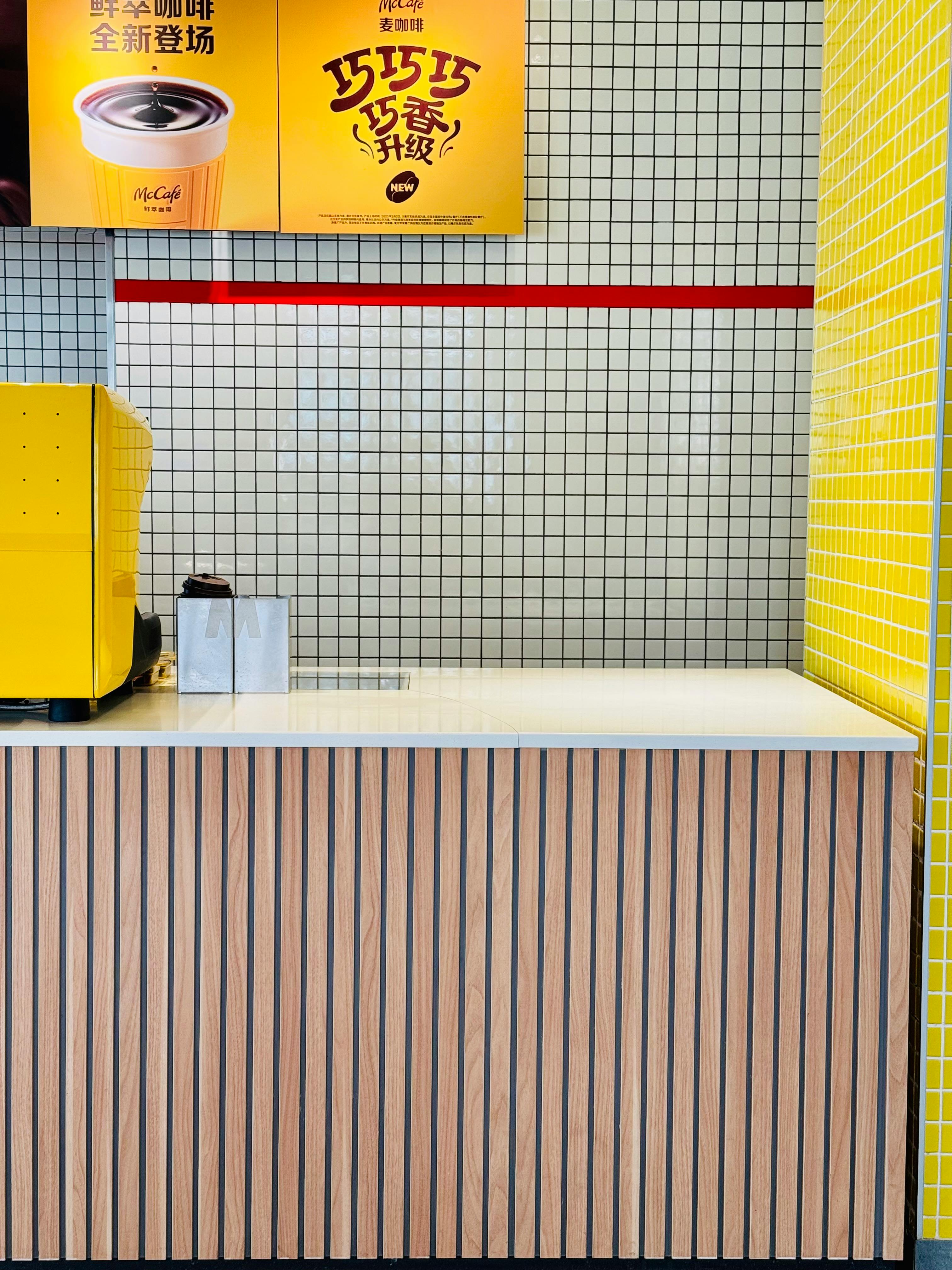 Stylish cafe counter with yellow tiles and coffee advertisement, ideal for modern cafes.