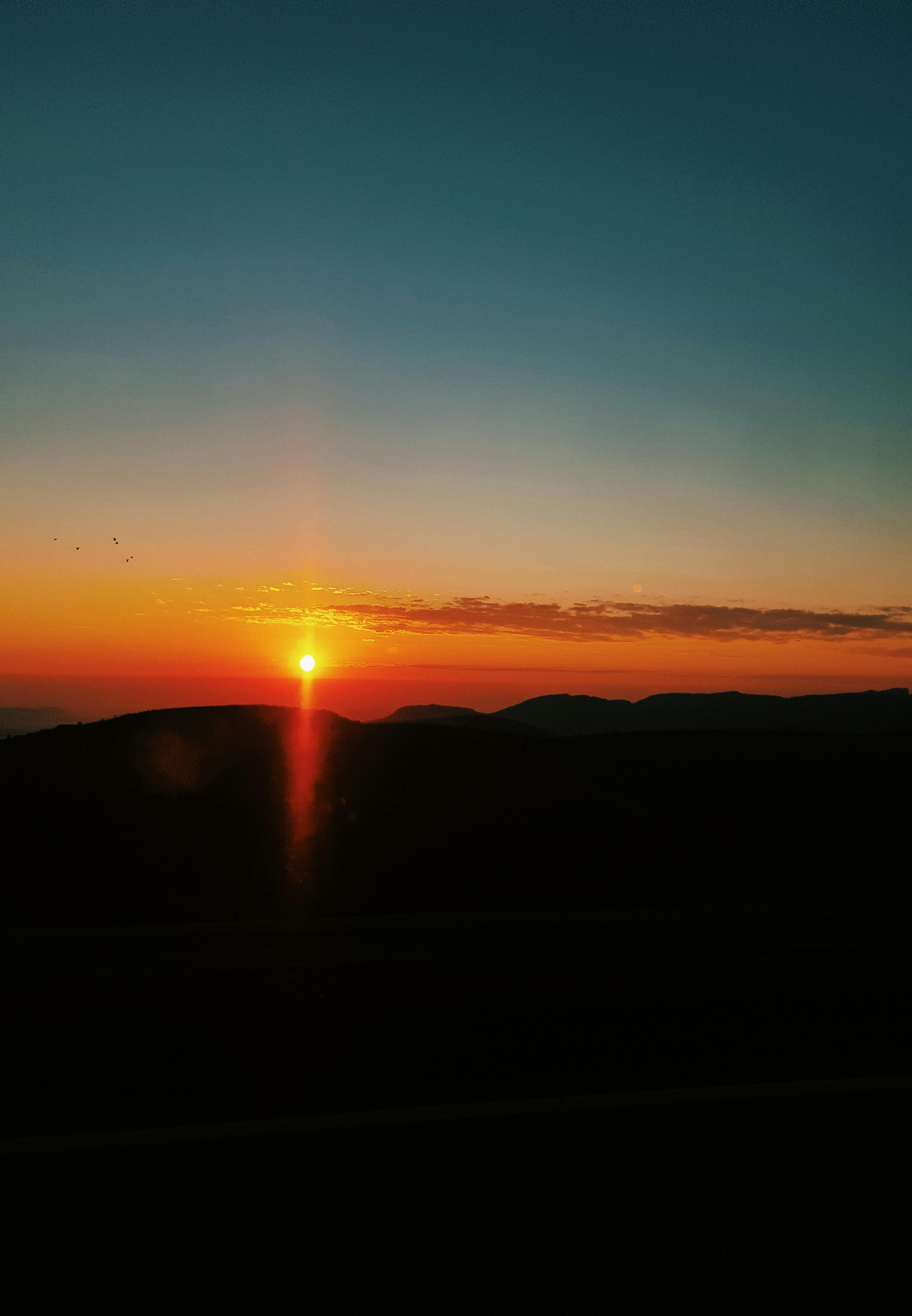 山丘的剪影映衬着美丽的日落与鲜艳的色彩