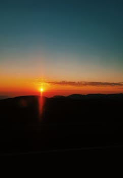 山丘的剪影映衬着美丽的日落与鲜艳的色彩