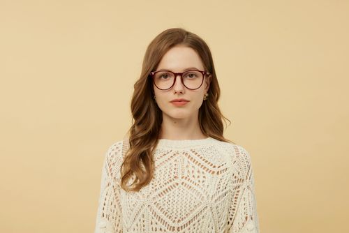Free Portrait of a stylish woman wearing glasses against a beige background. Stock Photo
