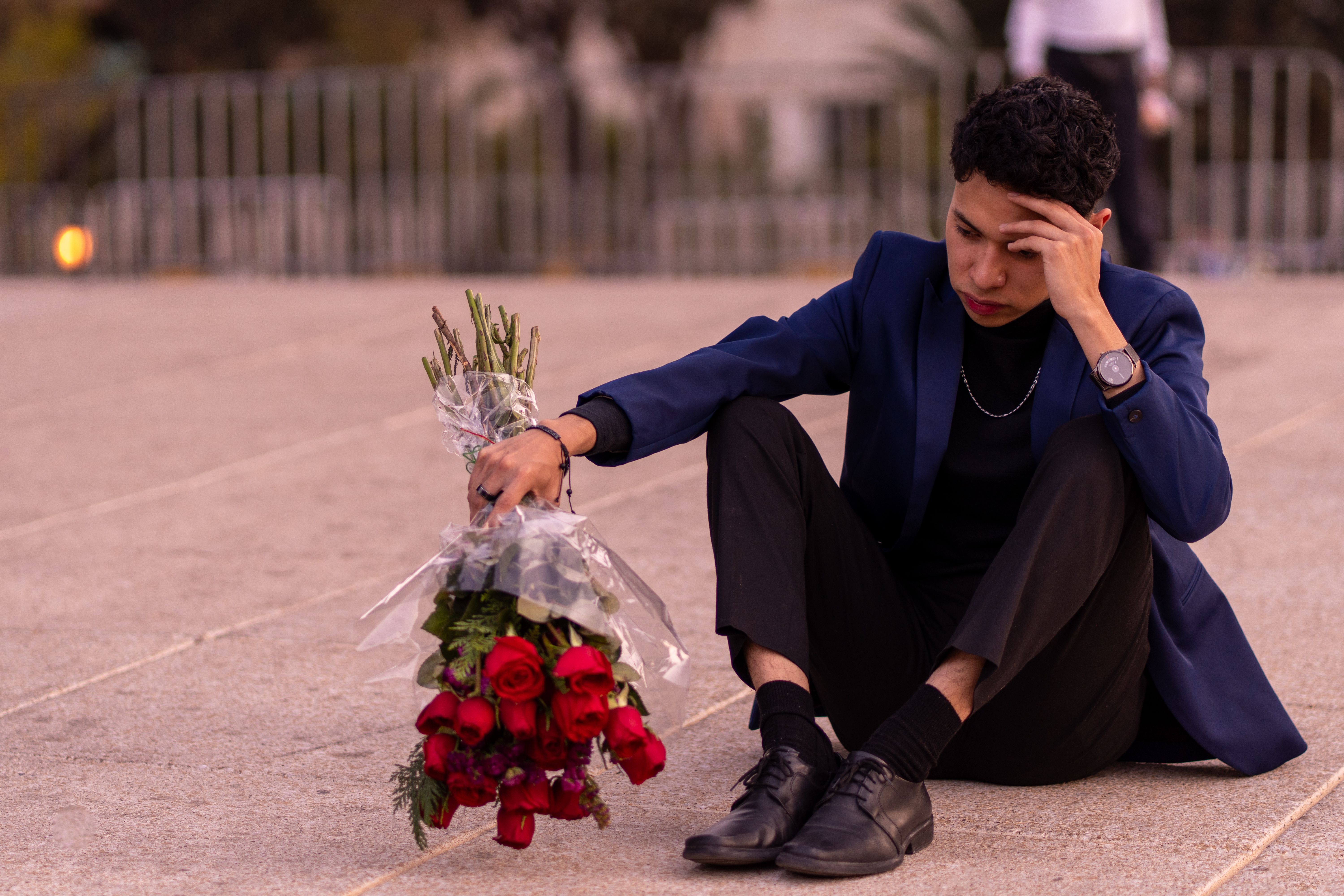 Thoughtful Young Man with Roses on Urban Plaza · Free Stock Photo
