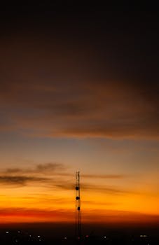 A striking silhouette of a tower during a vibrant sunset in Bengaluru, India.