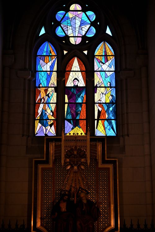 Free Colorful stained glass window depicting religious figures inside a church. Stock Photo