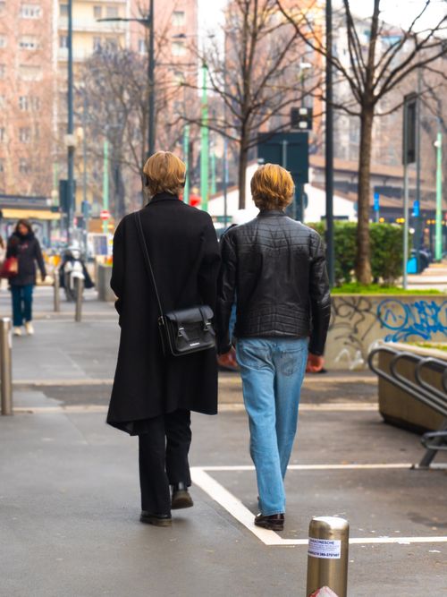 Free Two fashionable individuals walking in Milano's urban streets, showcasing contemporary style. Stock Photo