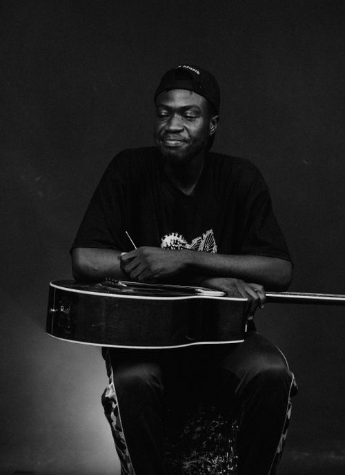 Free Black and white portrait of a man with an acoustic guitar, showcasing musical emotion. Stock Photo