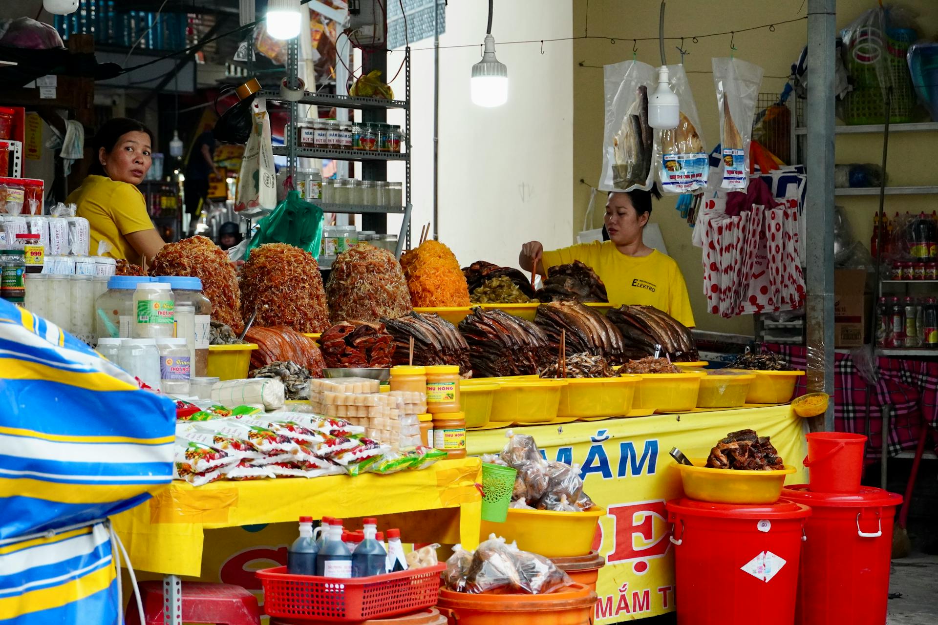 Lively Asian market scene with dried seafood and spices on display, showcasing local culture.