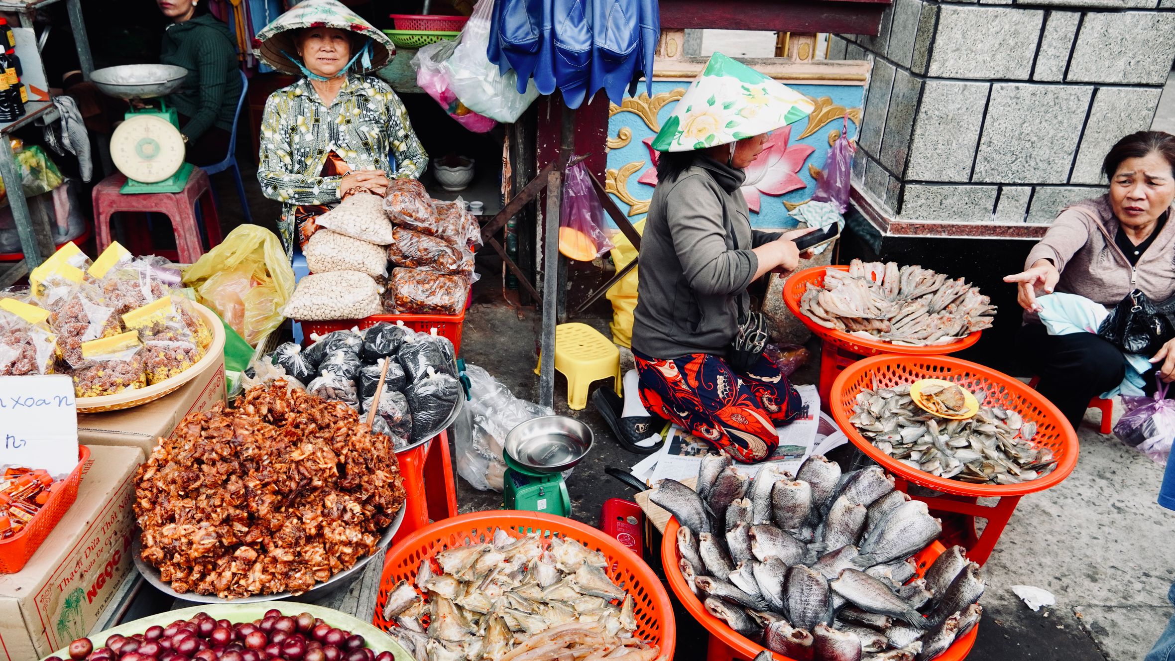 Lively Vietnamese street market with seafood and produce stalls.