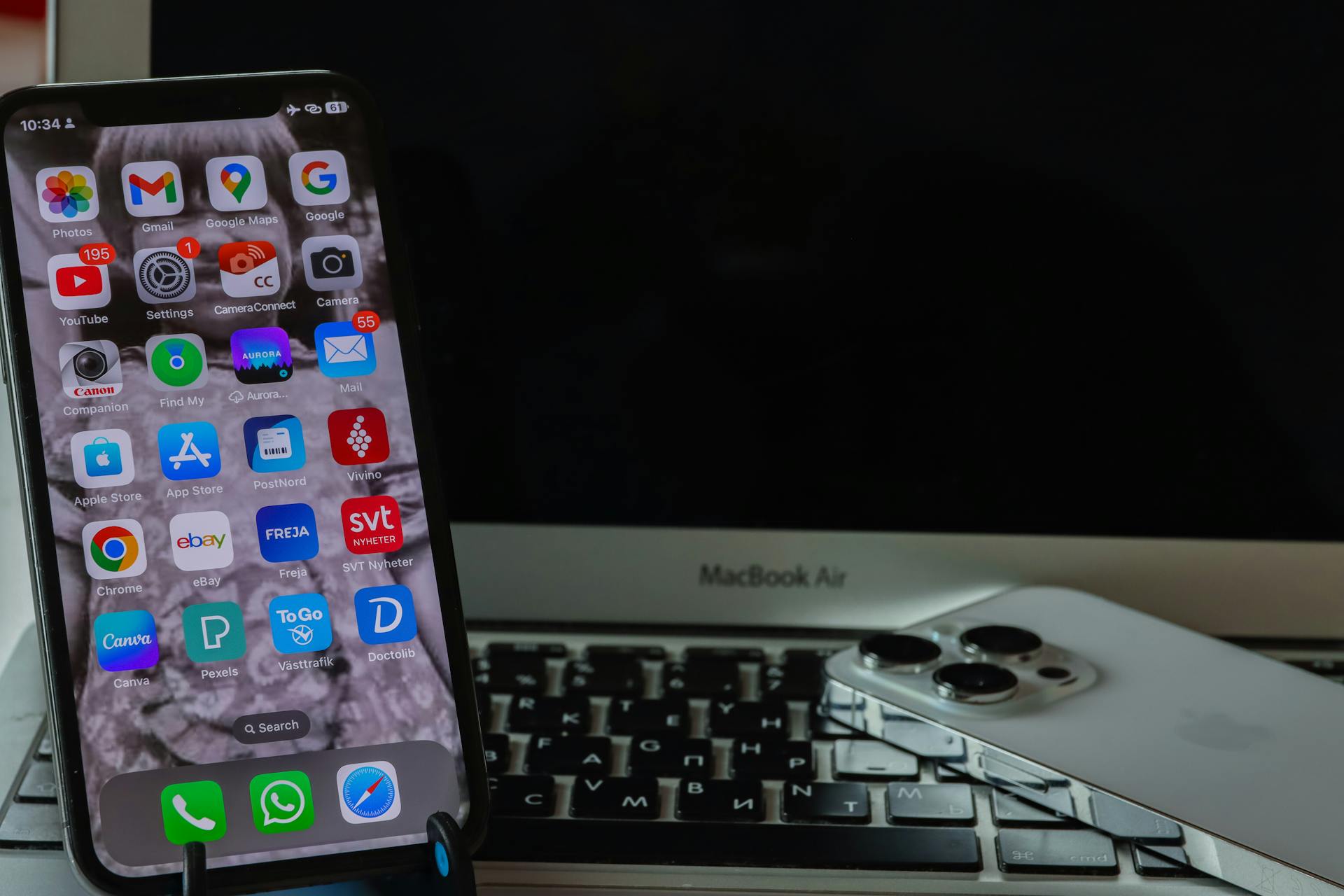 A smartphone and laptop setup showcasing a sleek, modern technology arrangement on a desk.