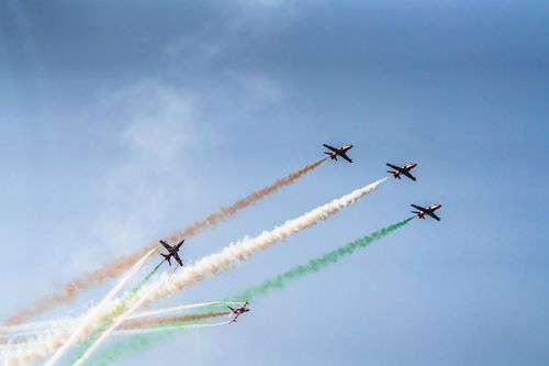 Безкоштовне Приголомшливий повітряний показ літаків із яскравими кольоровими слідами на фоні блакитного неба. стокове фото