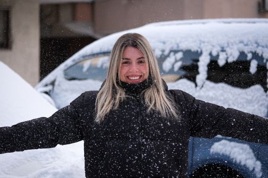 Portrait of a smiling woman enjoying snowfall in İstanbul, Türkiye.