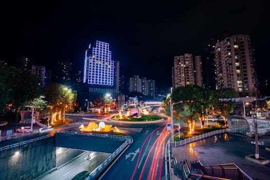 Colorful cityscape at night with light trails and illuminated buildings, showcasing urban energy.