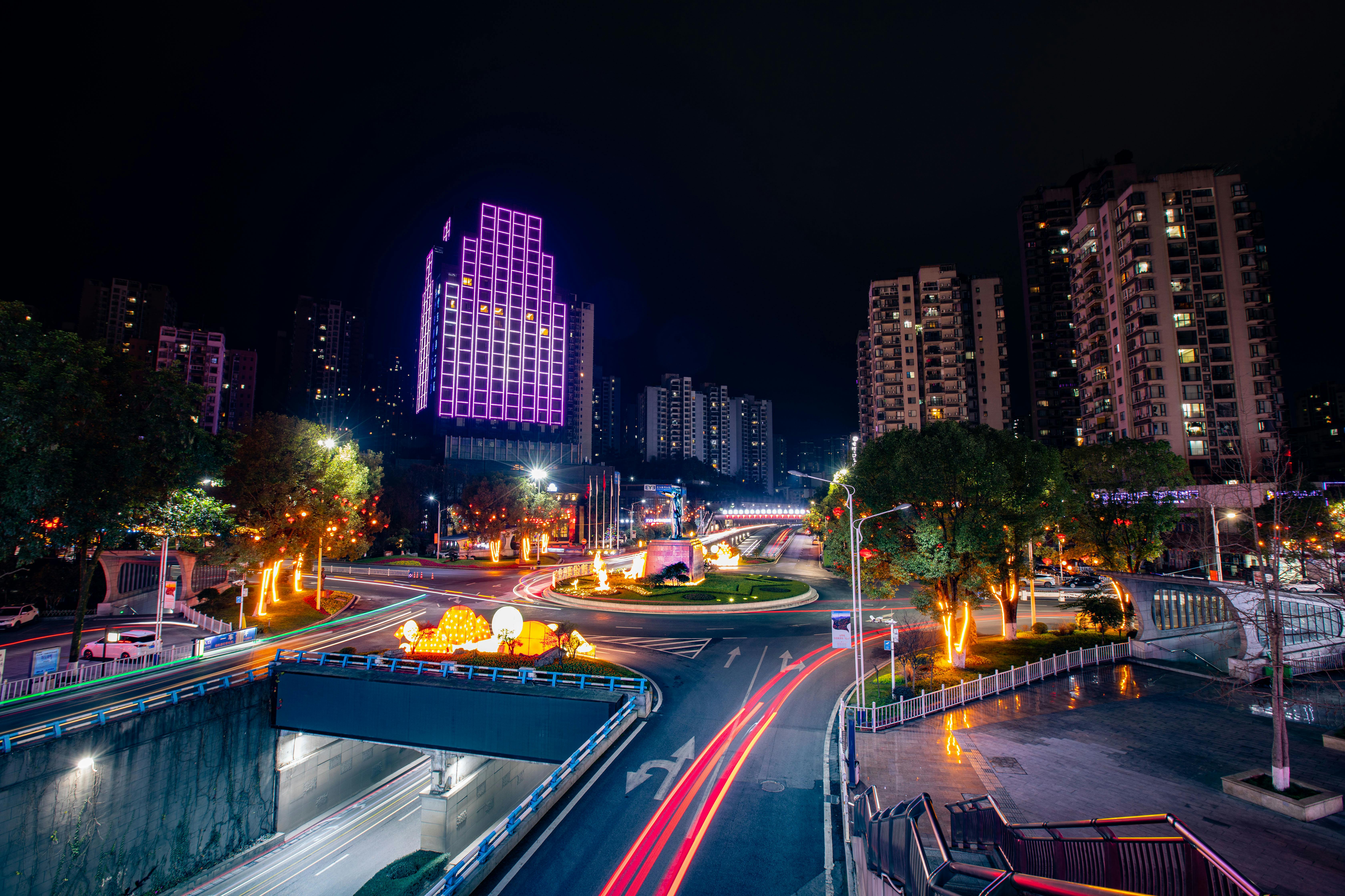 Stunning night cityscape with illuminated buildings and busy streets in vibrant colors.