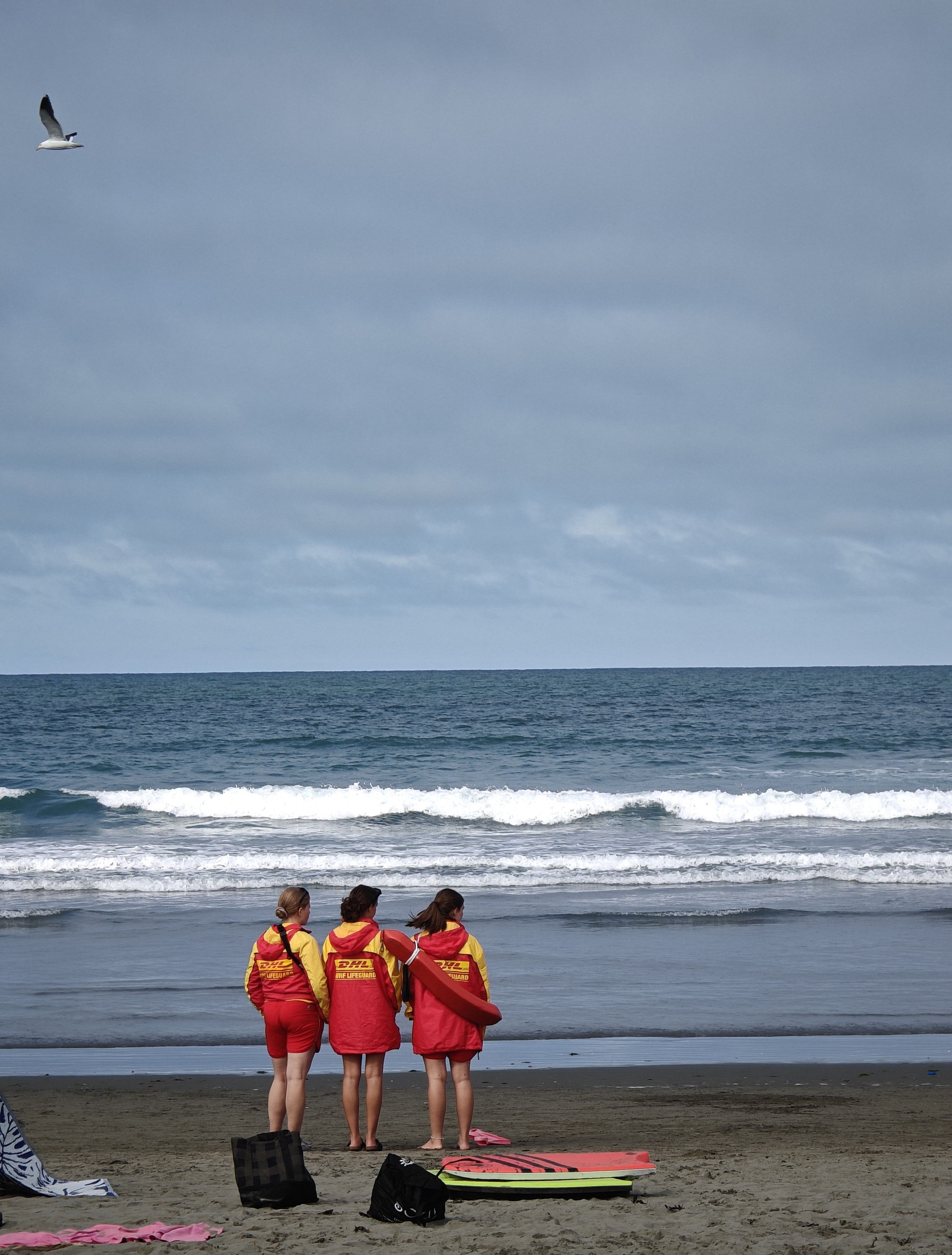 Australian surf lifesavers in red and yellow uniform on the beach
