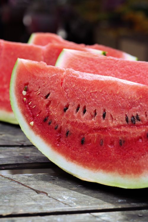 Free Close-up of juicy watermelon slices on a rustic wooden table, perfect for summer refreshment. Stock Photo