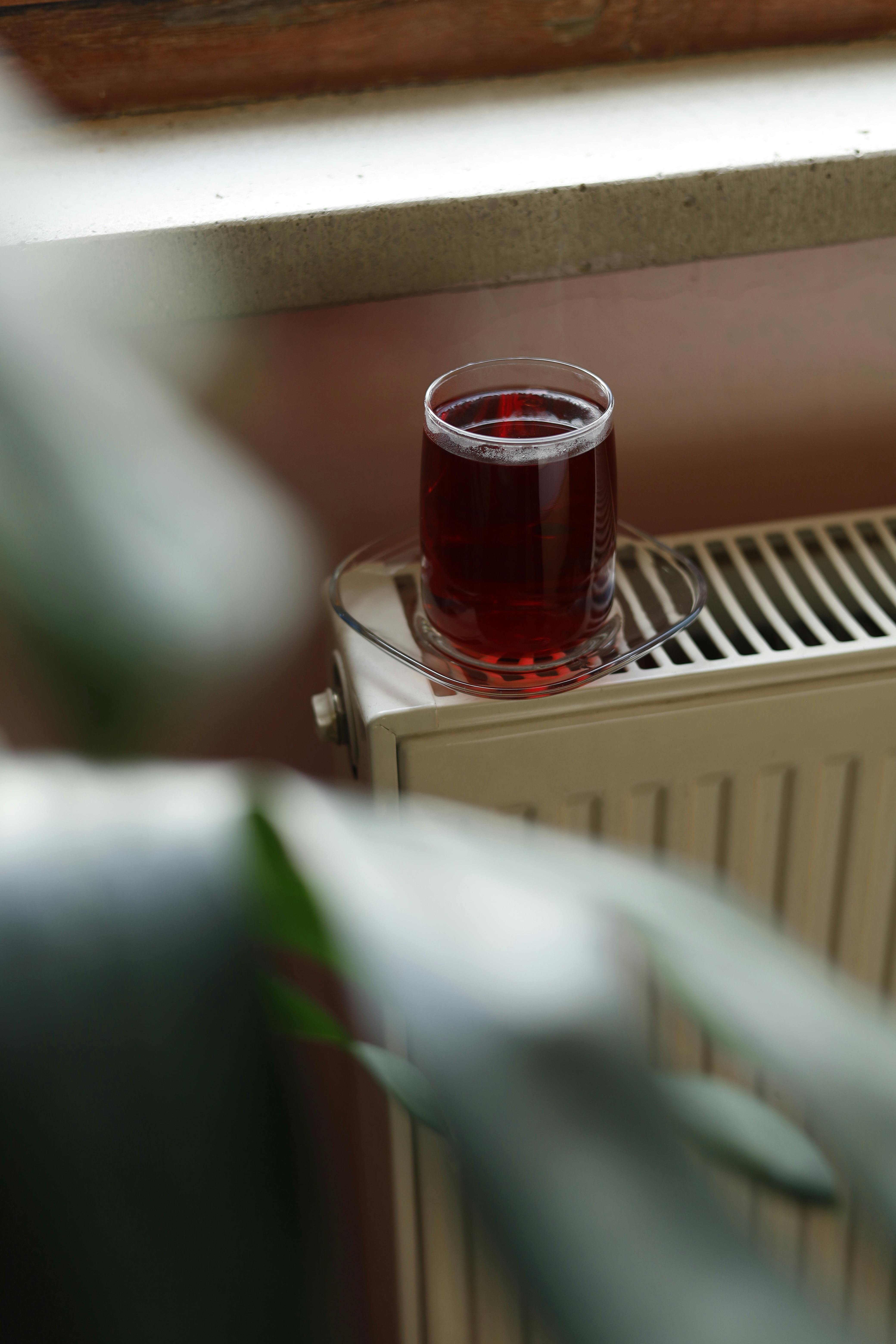 Glass of Herbal Tea on Radiator by Window · Free Stock Photo