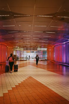 Vibrant airport hallway with people and luggage, offering a lively atmosphere.
