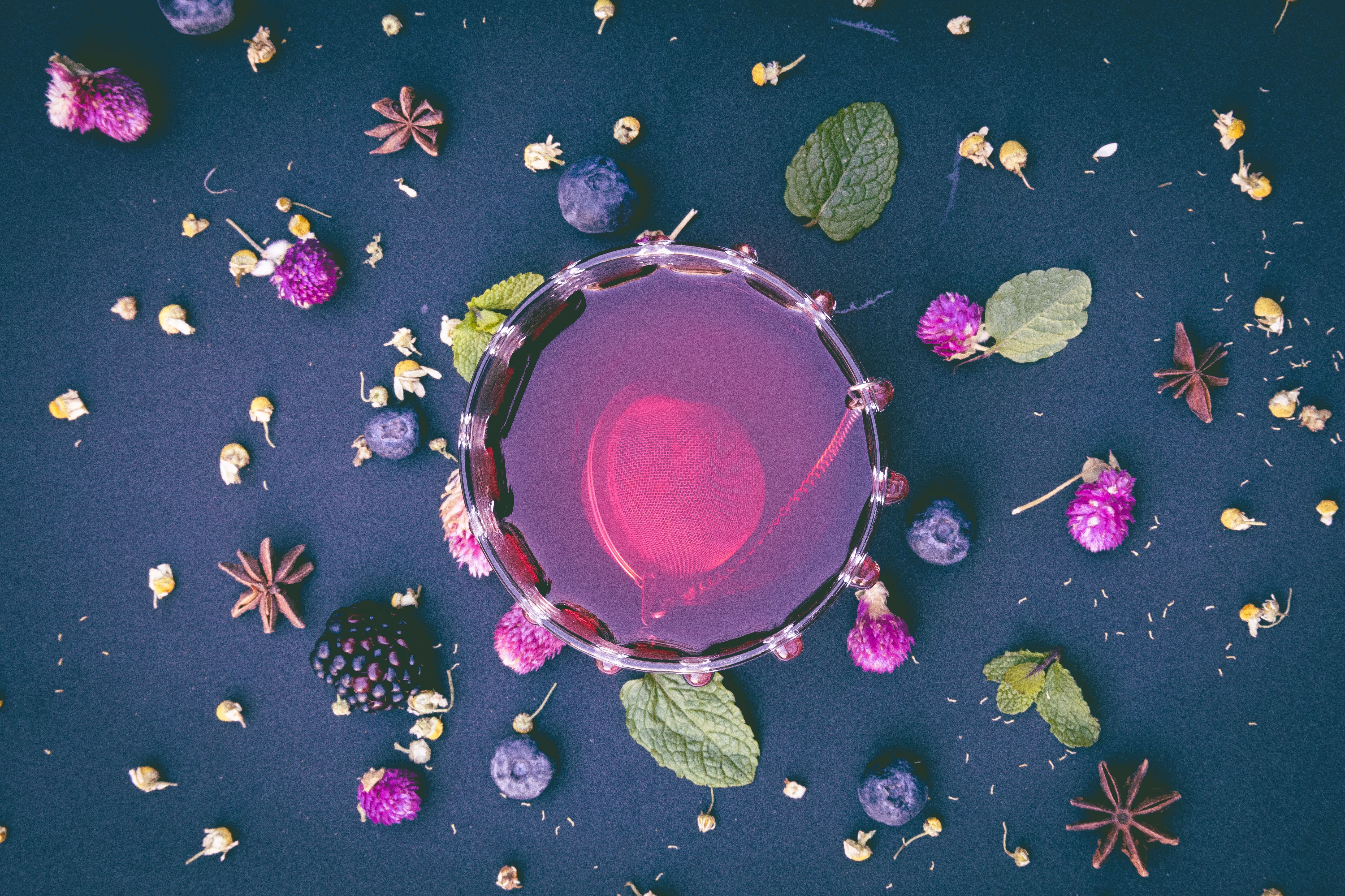 Free Colorful herbal tea flat lay with berries, flowers, and spices on a dark background, perfect for lifestyle and food themes. Stock Photo