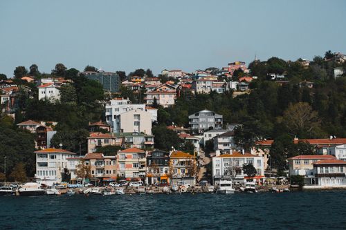 Free Charming coastal neighborhood view of Istanbul, featuring colorful houses and lush greenery. Stock Photo