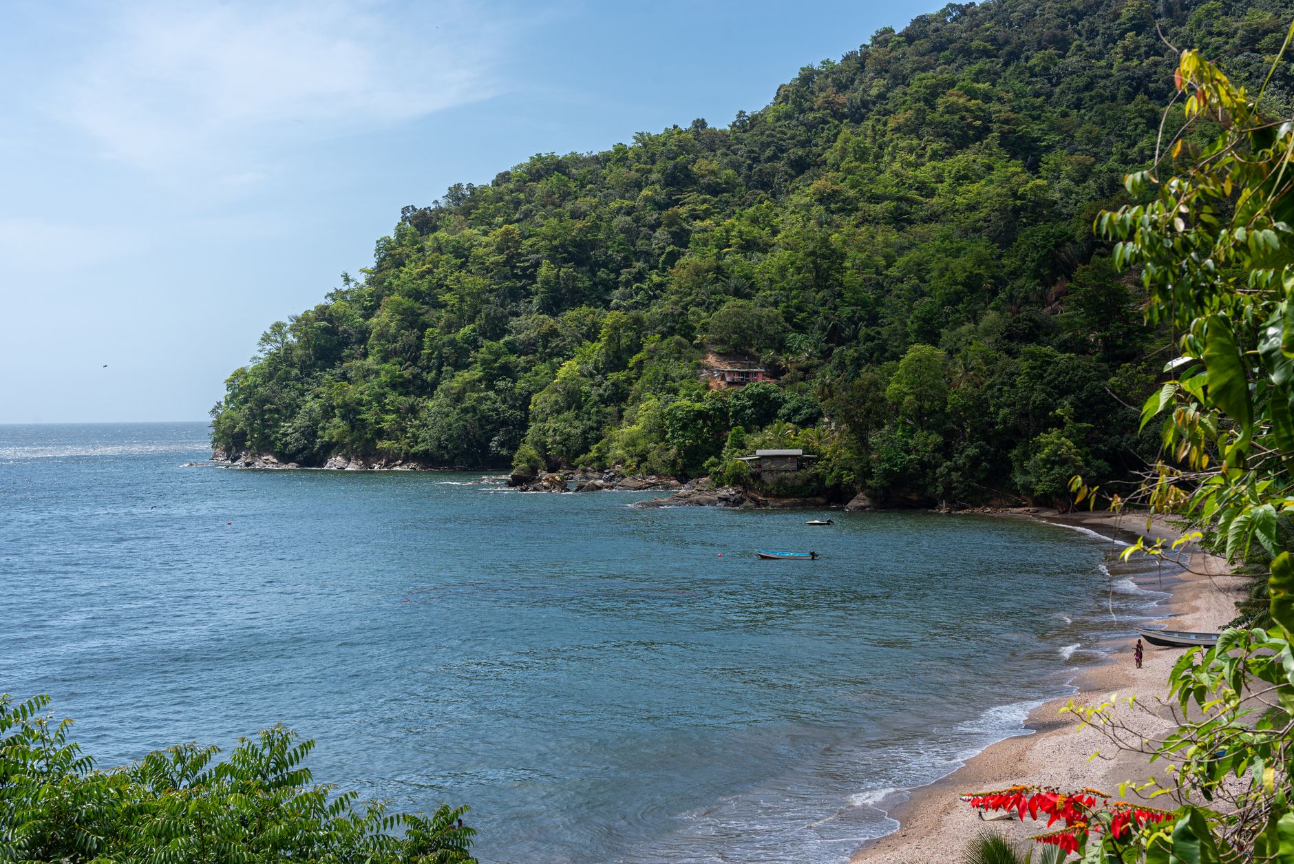 A tranquil view of Maracas Bay with lush greenery and clear blue waters in Trinidad and Tobago.