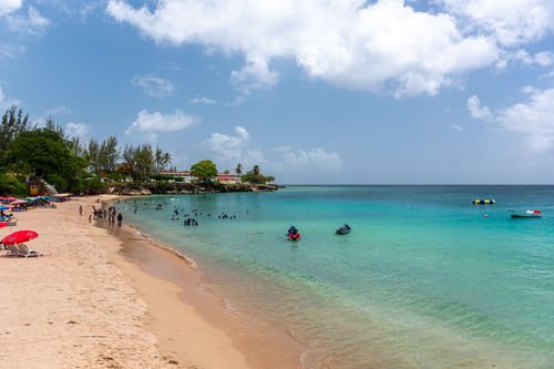 Free Enjoy the vibrant beach scene in Bon Accord Village, Tobago, with turquoise waters and leisure activities. Stock Photo