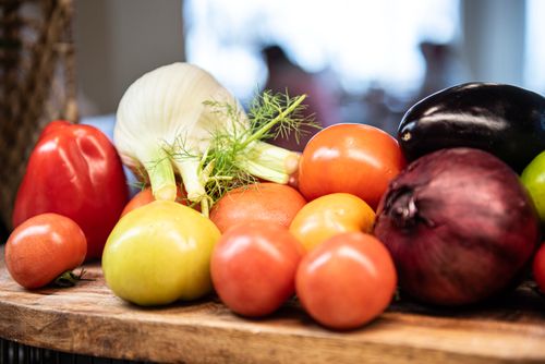 Free A colorful mix of fresh vegetables including tomatoes, peppers, and onions indoors. Stock Photo